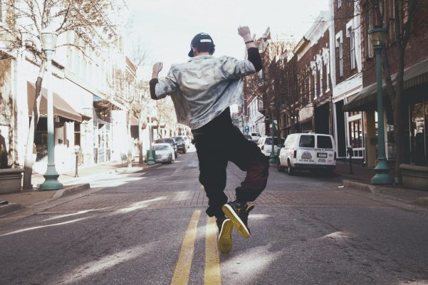 A man in sneakers dancing in the street.